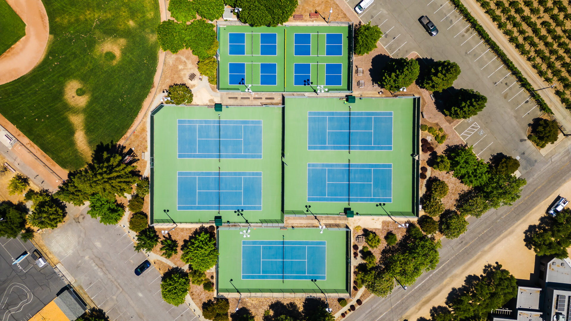 Aerial view of Five tennis courts and Four pickleball courts that were converted from a tennis court at Crane Park in St. Helena. The pickleball and tennis courts were reconstructed using the slipsheet overlay method and surfaced with Plexipave acrylic resurfacer in Dark Blue and Dark Green with white striping.