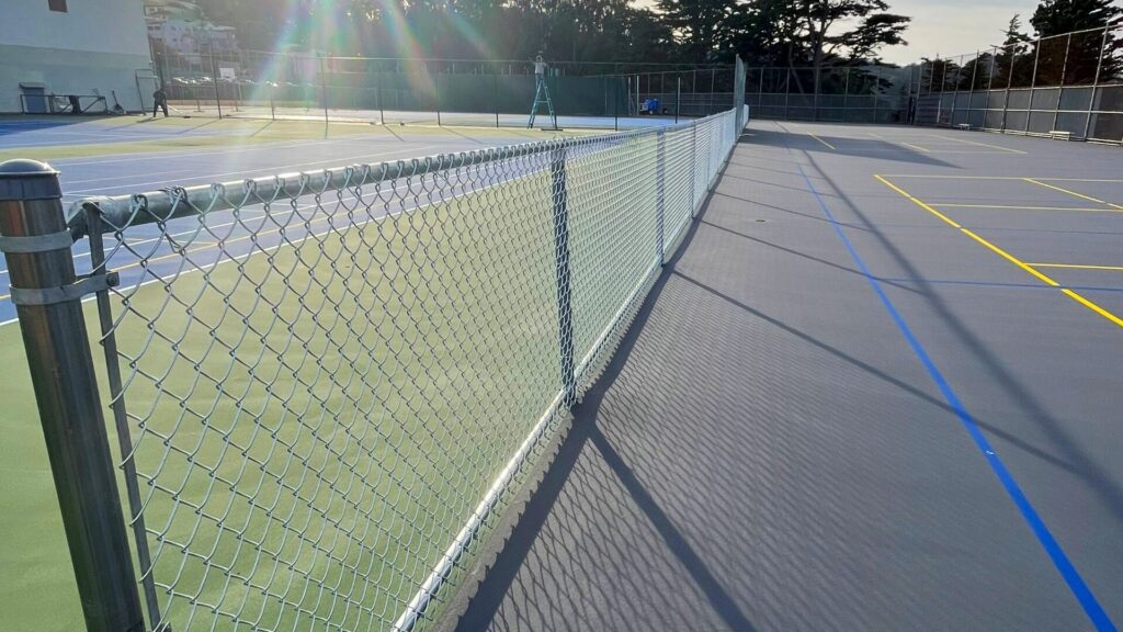 Chain link fencing around tennis court at high school